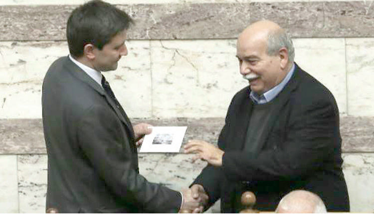 Ο πρόεδρος της Βουλής παραλαμβάνοντας το στικάκι του προϋπολογισμού από τον Γιώργο Χουλιαράκ