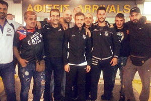 Ο Θανάσης Ντίνας στη μέση με φίλους του ΟΦΗ που υποδέχτηκαν την αποστολή στο αεροδρόμιο