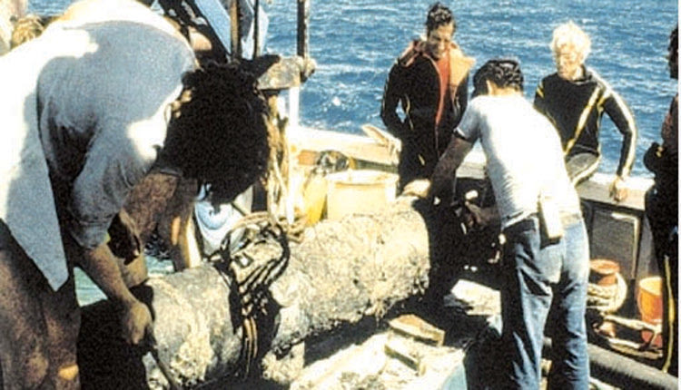 Ο Ζακ Ιβ Κουστώ και ο τότε επιμελητής αρχαιοτήτων Λάζαρος Κολώνας κατά τη διάρκεια του καθαρισμού του κανονιού, που ανελκύστηκε από τον χώρο του ναυαγίου του  La Therese
