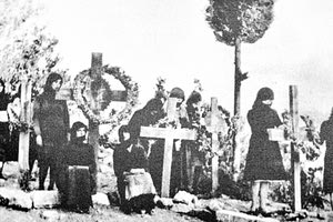 Μια μικρή άποψη των ομαδικών Τάφων στον προαύλιο χώρο της εκκλησίας του Αφέντη Σταυρού στο τέλος Ιουλίου έως τις αρχές Αυγούστου του 1945 κατά την επίσκεψη του Ν. Καζαντζάκη με τους Ι. Καλιτσουνάκη, Ι. Κακριδή και Κ. Κουτουλάκη, φωτογράφο