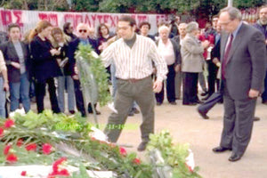 1999: Ο Αλέξης Τσίπρας, με μακριά μαλλιά, ζιβάγκο και πουκάμισο, καταθέτει στεφάνι και ο Νίκος Κωνσταντόπουλος (πατέρας της Ζωής Κωνσταντοπούλου), τότε πρόεδρος του Συνασπισμού, στέκεται δίπλα του.