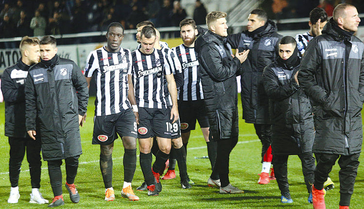 Σκυθρωποί αποχωρούν από το γήπεδο οι παίκτες του ΟΦΗ. 