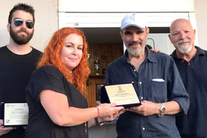 Ο κ. Δασκαλάκης δίνει την πλακέτα στη γυναίκα του Νίκου Γαλυφιανάκη