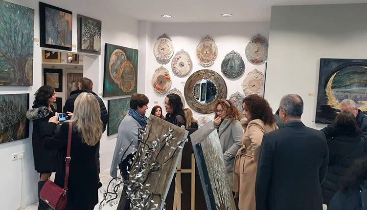 Η αστυνομικός από το Hράκλειο Μαρία Καφτάκη με τα έργα της, τα οποία εκτίθενται στο πλαίσιο της δεύτερης προσωπικής της έκθεσης που γίνεται στην πόλη.