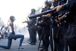 Μία νεαρή γυναίκα γονατίζει, βρίσκεται ανάμεσα στους χιλιάδες διαδηλωτές και το πλήθος των αστυνομικών που προτάσσουν τα όπλα τους. Είναι το νέο πρόσωπο της Αμερικής που φλέγεται, διαμαρτύρεται, πυρπολεί και δέχεται πυρά.