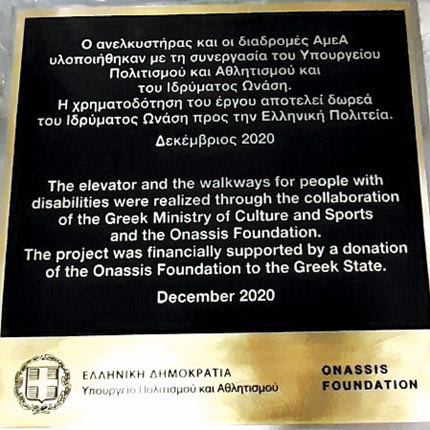 Η πινακίδα της δωρεάς του Ιδρύματος Ωνάση για τον ανελκυστήρα πλαγιάς στον βράχο της Ακρόπολης