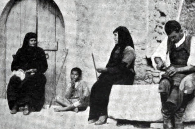 Ιστορική φωτό: Μεσσαρά, 1906. Τυπική οικογένεια με τον χωρικό να φτιάχνει τα στιβάνια του. Φωτογραφία του Μπεχαεντίν.