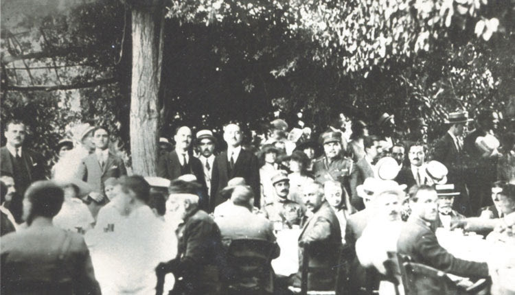 Αρχάνες, Αύγουστος 1923, Εξοχικό κέντρο «Το Μυριόφυτο». Ο στρατηγός Ν. Πλαστήρας περιοδεύει στην Κρήτη για να επισπεύσει το πρόγραμμα μετεγκατάστασης και αποκατάστασης των Ελλήνων προσφύγων μετά από τη Μικρασιατική Καταστροφή. Η έδρα της επίσκεψης ήταν οι Αρχάνες στις οποίες ο Πλαστήρας διέμενε για 3 νύχτες φιλοξενούμενος του αντισυνταγματάρχη χωροφυλακής Γ. Καλοχριστιανάκη. Ο Πλαστήρας στο κέντρο καθήμενος. Πίσω του όρθιος ο Καλοχριστιανάκης. (Πηγή: Προσωπικό οικογενειακό αρχείο του γράφοντος