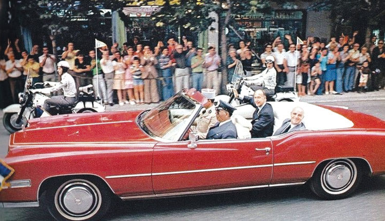 Φωτογραφία-ντοκουμέντο από τη στήλη. Είναι από την επίσημη επίσκεψη του προέδρου της Γαλλικής Δημοκρατίας Βαλερί Ζισκάρ Ντ' Εστέν στην Ελλάδα, στο διάστημα 17-21 Σεπτεμβρίου 1975. Χαμογελαστοί στο κάμπριο μαζί με τον Κωνσταντίνο Καραμανλή