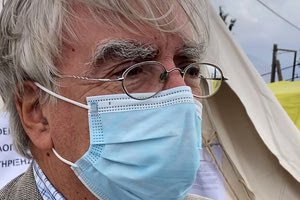 Ο κ. Βγόντζας με φόντο τις σκηνές του Αρκαλοχωρίου