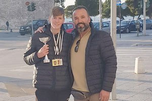 Ο Αντώνης Δημόπουλος με το κύπελλο και τα μετάλλια του έχοντας δίπλα τον προπονητή - πατέρα του Γιάννη