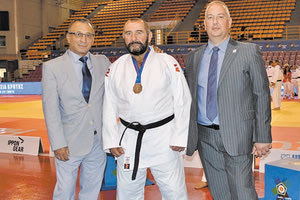 Ο Ανδρεάδης με το μετάλλιο στο στήθος του. Στην ένθετη φωτό, στιγμιότυπο από τους αγώνες που γίνονται στα «Δύο Αοράκια»