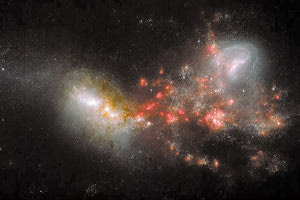 Εικόνα του γαλαξία VV114 όπως παρατηρήθηκε από το James Webb. Οι περιοχές με σκόνη που δεν ήταν εμφανείς μέχρι σήμερα έχουν κόκκινο χρώμα