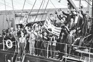 Έλληνες μετανάστες αναχωρούν με το πλοίο από τη Νέα Υόρκη για να λάβουν μέρος στον Α΄ Βαλκανικό Πόλεμο (1912). Κρατούν την ελληνική σημαία με φωτογραφία του Ελευθερίου Βενιζέλου