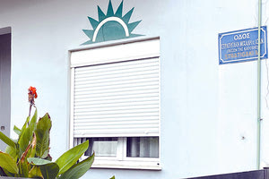 Από τα κατεβασμένα στόρια του παραθύρου, δύσκολα θα εισχωρήσει ο ήλιος εντός του δωματίου. Στο μεταξύ το σπίτι, κάπου στην ενδοχώρα του Ηρακλείου, εξακολουθεί να παραμένει ευήλιον