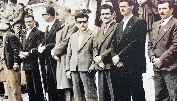 Καστέλλι Πεδιάδος, παρέλαση 28ης Οκτωβρίου 1971. Οι ανάπηροι πολέμου του Καστελλίου σε τιμητική θέση παρακολουθούν την παρέλαση. Από αριστερά: Μπουμπουλάκης Κωνσταντίνος, Μαραυγάκης Εμμανουήλ, Χαραλαμπάκης Γεώργιος, Σγουροβασιλάκης Αντώνιος, Βαϊλάκης Εμμανουήλ, Μαράκης Ιωάννης, Ξυδάκης Στυλιανός και Παπαδάκης Φραγκίσκος