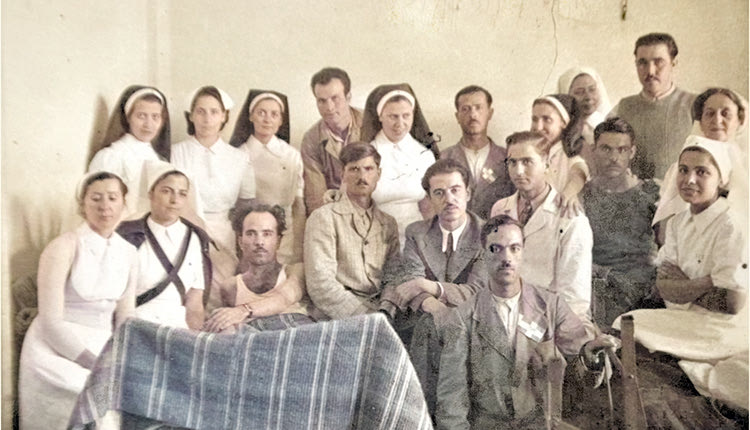 13ο Στρατιωτικό Νοσοκομείο Αθηνών. Τέταρτος από αριστερά, (μετά τις τρεις Νοσοκόμες στην πάνω σειρά), ο παγόπληκτος Γεώργιος Χαραλαμπάκης.  Στις 24 Φεβρουαρίου 1941, ο Γεώργιος Χαραλαμπάκης αποσύρθηκε από το ύψωμα 1178 της Τρεμπεσίνας με κρυοπαγήματα. Στη συνέχεια, στο χειρουργείο του Στρατιωτικού Νοσοκομείου Ιωαννίνων, έχασε τα κάτω άκρα του από γάγγραινα και μεταφέρθηκε για ανάρρωση στο νοσοκομείο των Αθηνών