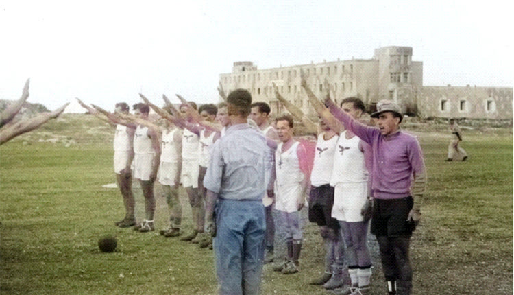 Αλικαρνασσός Ηρακλείου 1943, (σημερινές Φυλακές). Δύο γερμανικές ομάδες ετοιμάζονται να ξεκινήσουν ποδοσφαιρικό αγώνα. Οι παίκτες χαιρετιούνται μεταξύ τους με τον ναζιστικό τρόπο. (Greece at WW2 archives)