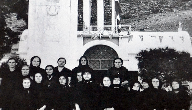 Μαυροφορεμένες γυναίκες της Κρύας Βρύσης στέκονται μπροστά στο μνημείο του χωριού τους. Άλλες έχασαν τον άντρα τους, άλλες τα παιδιά τους, άλλες τα αδέλφια τους. Στέκονται εκεί,  σε μια φωτογραφία που έχει τη δική της φωνή. Μια φωτογραφία - «φραγμός» στη λήθη και την αναθεώρηση της Ιστορίας. (Πηγή: Ημερολόγιο Πολιτιστικού).