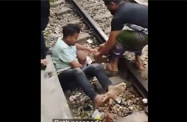 Πατέρας καλύπτει το παιδί του καθώς το τρένο περνά από πάνω τους σε σταθμό του Μπαγκλαντές